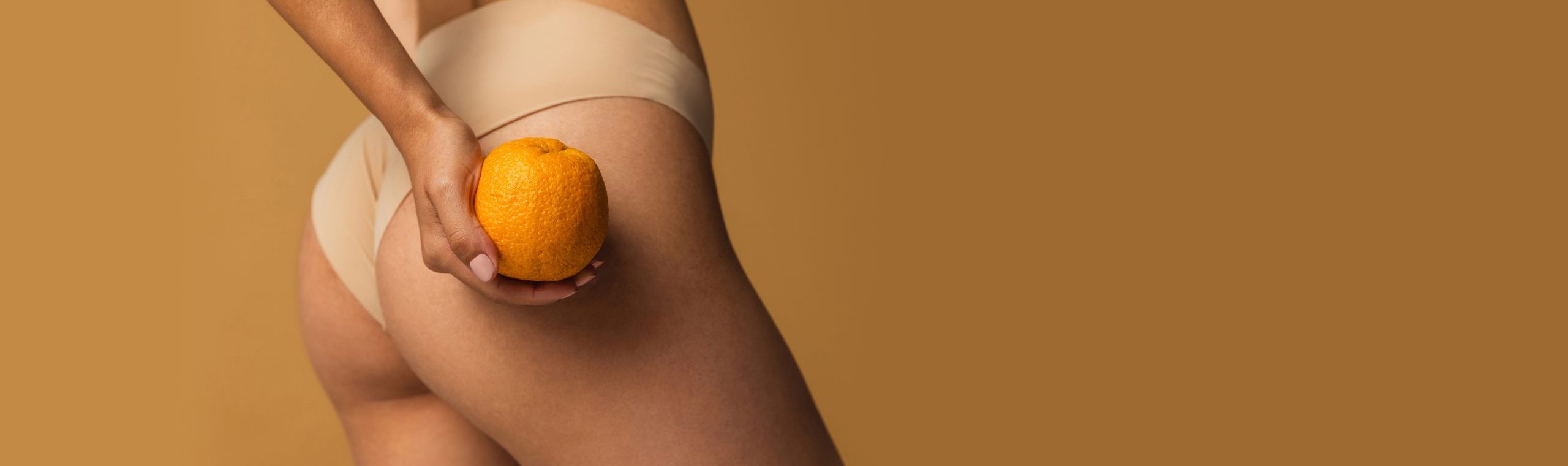 Cropped,Image,Of,Slim,Smooth,Female,Legs,,Buttocks,With,Orange Bindweefsel Cellulite Behandeling